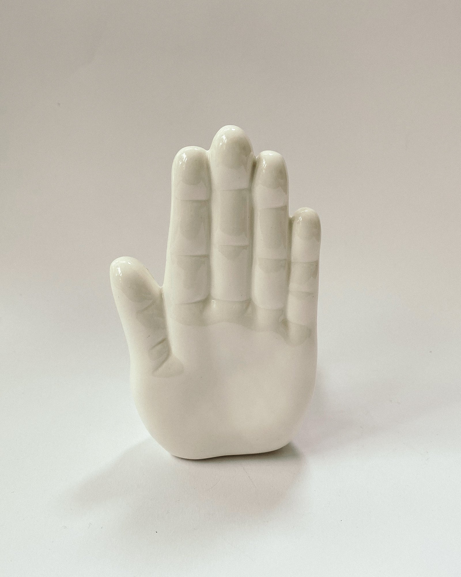 weiße Buchstütze in Form einer Hand